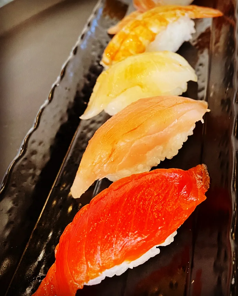 Assortment of sushi nigiri on a black plate